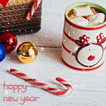 Аватар Кружка c нарисованной мордочкой оленя стоит на столе, рядом лежат новогодние шары и сладости (happy New Year / счастливого Нового года)